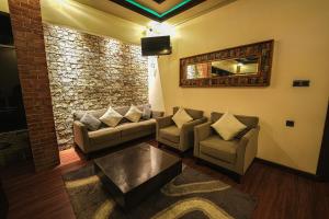 a living room with a couch and chairs and a mirror at Friendly Hills Hotel in Nuwara Eliya