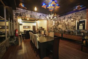 a dining room with a table and a stone wall at Friendly Hills Hotel in Nuwara Eliya +17 photos
