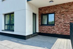 a building with two windows and a brick wall at Apartament Stara Fabryka 3 in Włocławek