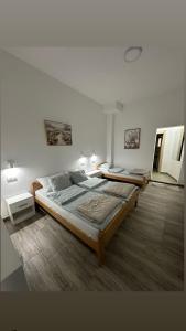 two beds in a white room with at Apartman Milanović in Pribojska Banja