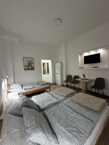 a white room with two beds and a table at Apartman Milanović in Pribojska Banja