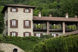a large stone house with windows and a balcony at Relaisfranciacorta in Corte Franca