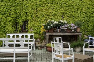 a group of white chairs and a fireplace with flowers at Relaisfranciacorta in Corte Franca