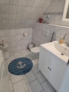 a bathroom with a sink and a toilet and a rug at Ferienwohnung Ahoi in Langwedel +12 photos
