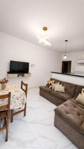 a living room with two couches and a table at Beach House 96 in Itanhaém