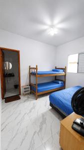 a bedroom with two bunk beds and a mirror at Beach House 96 in Itanhaém +8 photos