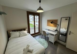 a bedroom with a bed and a desk and a mirror at T5 cosy lumineux in Amiens