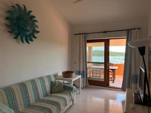 a living room with a couch and a view of the ocean at Residenze Coda Cavallo in San Teodoro