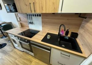 a kitchen with a sink and a stove at T5 cosy lumineux in Amiens +3 photos