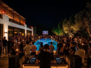 a crowd of people standing around a pool at night at Alya Hill Bodrum in Bodrum City +35 photos