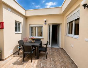 a patio with a black table and chairs at R&A Apartments in Berat