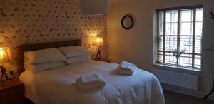 a bedroom with a white bed with two towels on it at The Star Inn in North Dalton