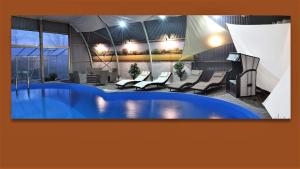 a large pool in a room with chairs and lights at Ferienwohnung Komfort in Hakendorferwurp