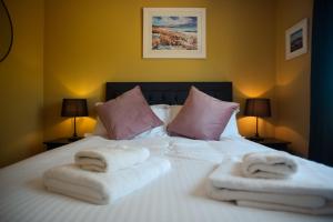 a bedroom with a bed with two towels on it at Penlarach House in Oban