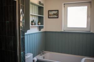 a bathroom with a bath tub and a window at Penlarach House in Oban +31 photos