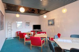 a waiting room with tables and chairs and a tv at Atelier Probst Schönwald in Aufʼm Bühl