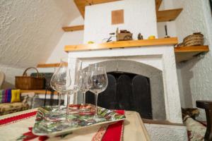 two wine glasses sitting on a table in front of a fireplace at Chalet Etna dreamers in Nicolosi