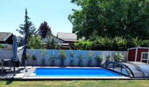 a swimming pool in a backyard with a fence at Ferienwohnung an der Singold in Holzhausen bei Buchloe