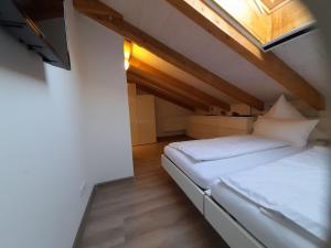 a bedroom with a white bed with a window at Ferienwohnung an der Singold in Holzhausen bei Buchloe