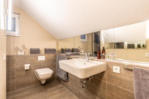 a bathroom with a sink and a toilet and a mirror at Riff5 Wohnung 6 in Borkum