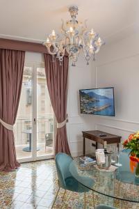 a living room with a glass table and a chandelier at Hotel Marina Riviera in Amalfi