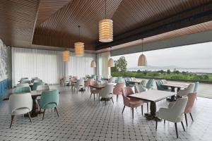 a restaurant with tables and chairs and a large window at The Haven by Sula in Nashik