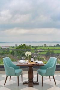 a dining table with two chairs and a view of the ocean at The Haven by Sula in Nashik