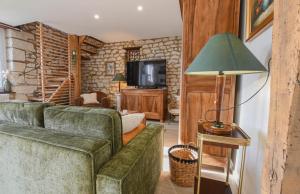 a living room with two green couches and a television at Gite de l'entente in Macey