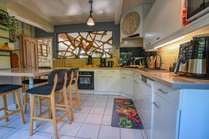 a kitchen with a counter and some chairs in it at Gite de l'entente in Macey +17 photos
