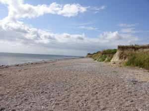 a rocky beach next to the ocean on a cloudy day at Klingl Ankerplatz Muschel in Schönhagen