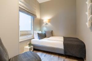 a small bedroom with a bed and a window at Pier17 Appartement 1 in Borkum +6 photos