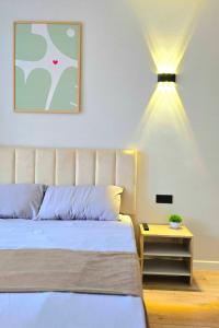 a bedroom with a bed and a table with a lamp at Жк "AUEZOV" in Kokshetau