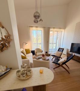 a living room with a couch and a table at White & Wood Suite C302, at Euphoria SPA Borovets in Borovets