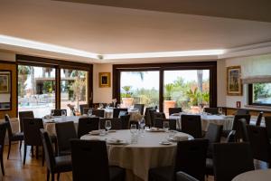 a dining room with tables and chairs and windows at Baia Di Ulisse Wellness & Spa in San Leone
