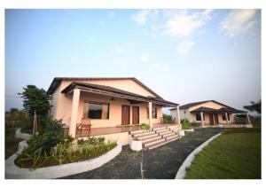 a house with stairs and a grass yard at Dream Habitat Resort in Mohurli