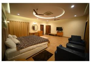 a bedroom with a bed and a couch and a chair at Dream Habitat Resort in Mohurli