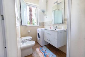 a bathroom with a toilet sink and a washing machine at VILLA FRANCA in Fontane Bianche +58 photos