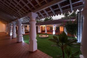 a large outdoor patio area with a large lawn at Siolim House in Siolim