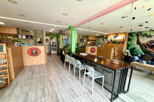 a restaurant with a bar with white chairs in it at Lazy Gibbon 1 Chiang Mai - Tha Phae Gate in Chiang Mai