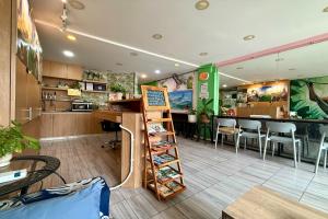 a restaurant with a bar and a counter with chairs at Lazy Gibbon 1 Chiang Mai - Tha Phae Gate in Chiang Mai