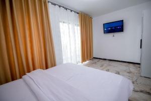 a bedroom with a white bed and an orange curtain at Nibiru Sea View in Costinesti