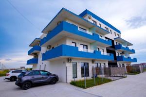 a blue and white building with a car parked in front at Nibiru Sea View in Costinesti