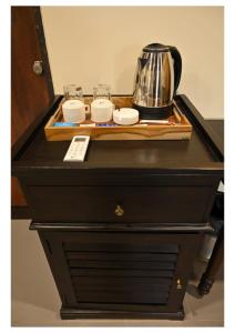 a black dresser with a tea pot and cups on it at Dream Habitat Resort in Mohurli
