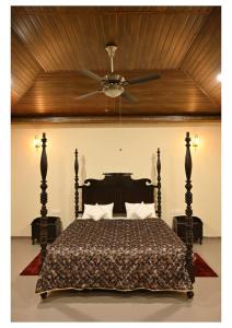 a bedroom with a bed with a ceiling fan at Dream Habitat Resort in Mohurli