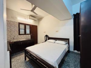 a bedroom with a bed and a ceiling fan at Fort Grande ONE in Cochin