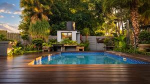 a swimming pool in a backyard with a wooden deck at Rose cottage Garden Suite in Pretoria