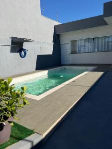 a swimming pool in the side of a house at casa da piscina e churrasco in Maringá