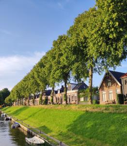 a row of houses next to a river at De Tegel Suite in Anjum