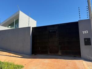 a building with a large metal gate with a fence at casa da piscina e churrasco in Maringá