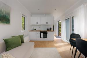a living room with a white couch and a kitchen at Hygge Tiny House 2 - Berlin Brandenburg in Berlin +24 photos